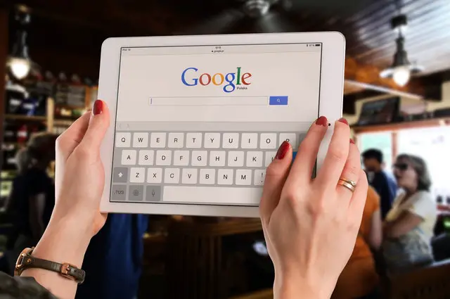 person holding a tablet opening google