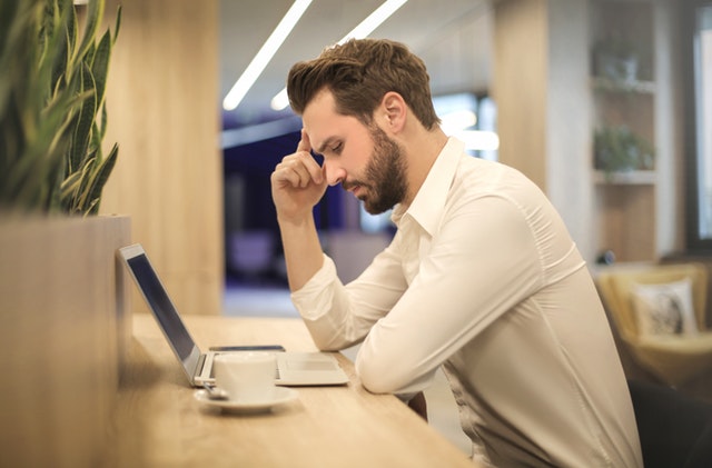 man frowning in front of computer