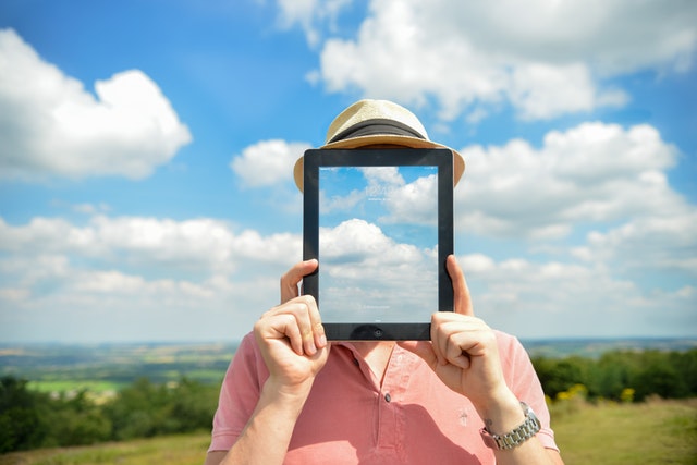 man holding an ipad showing clouds