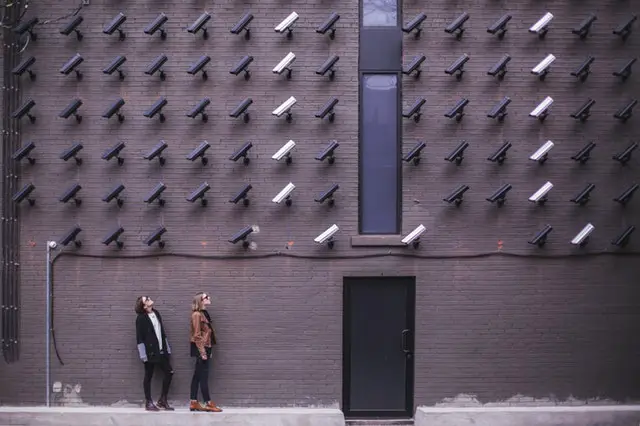 two people standing under dozens of CCTV