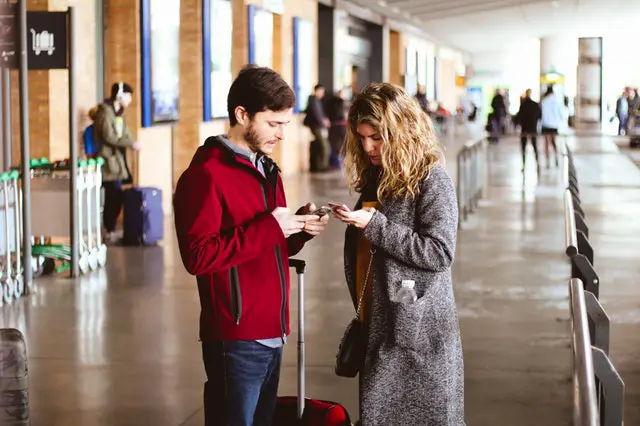 people using smartphone at an airport