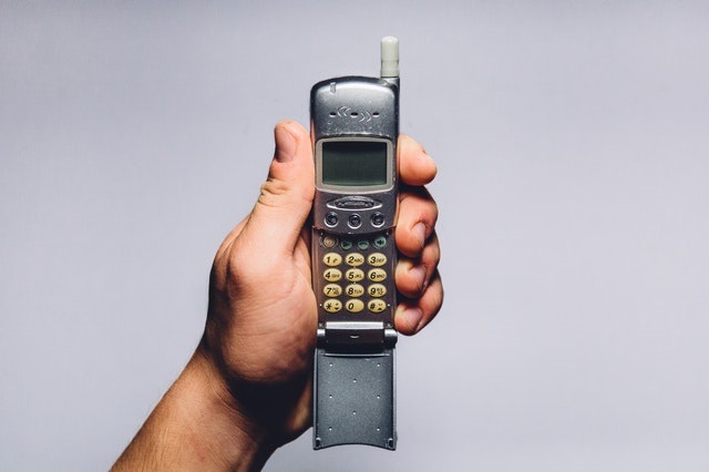 A man holding an old antenna mobile phone