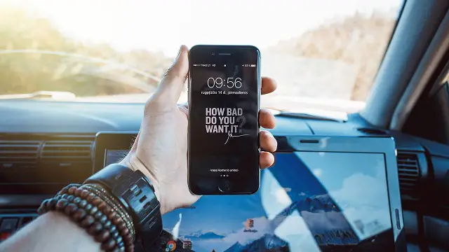 A man in the car holding a smartphone