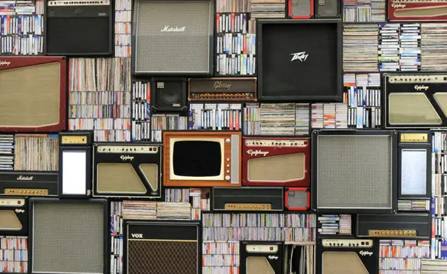 A stack of music and some vinyl and speakers