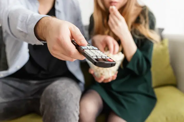 people on couch with a remote controle