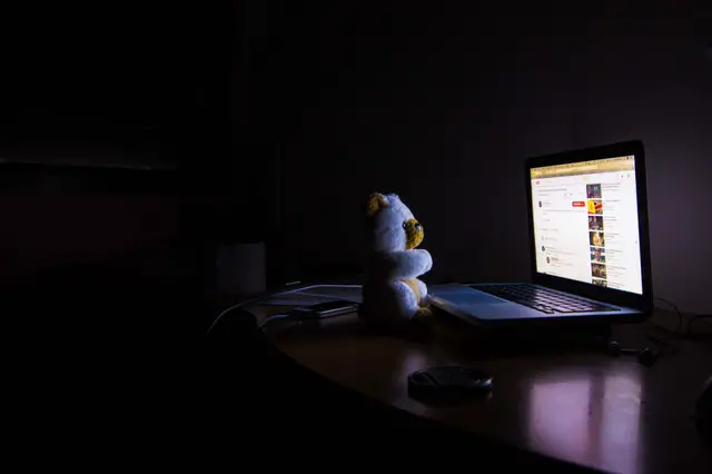 teddy bear in front of a computer screen