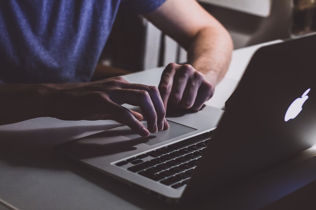 a man typing on a laptop