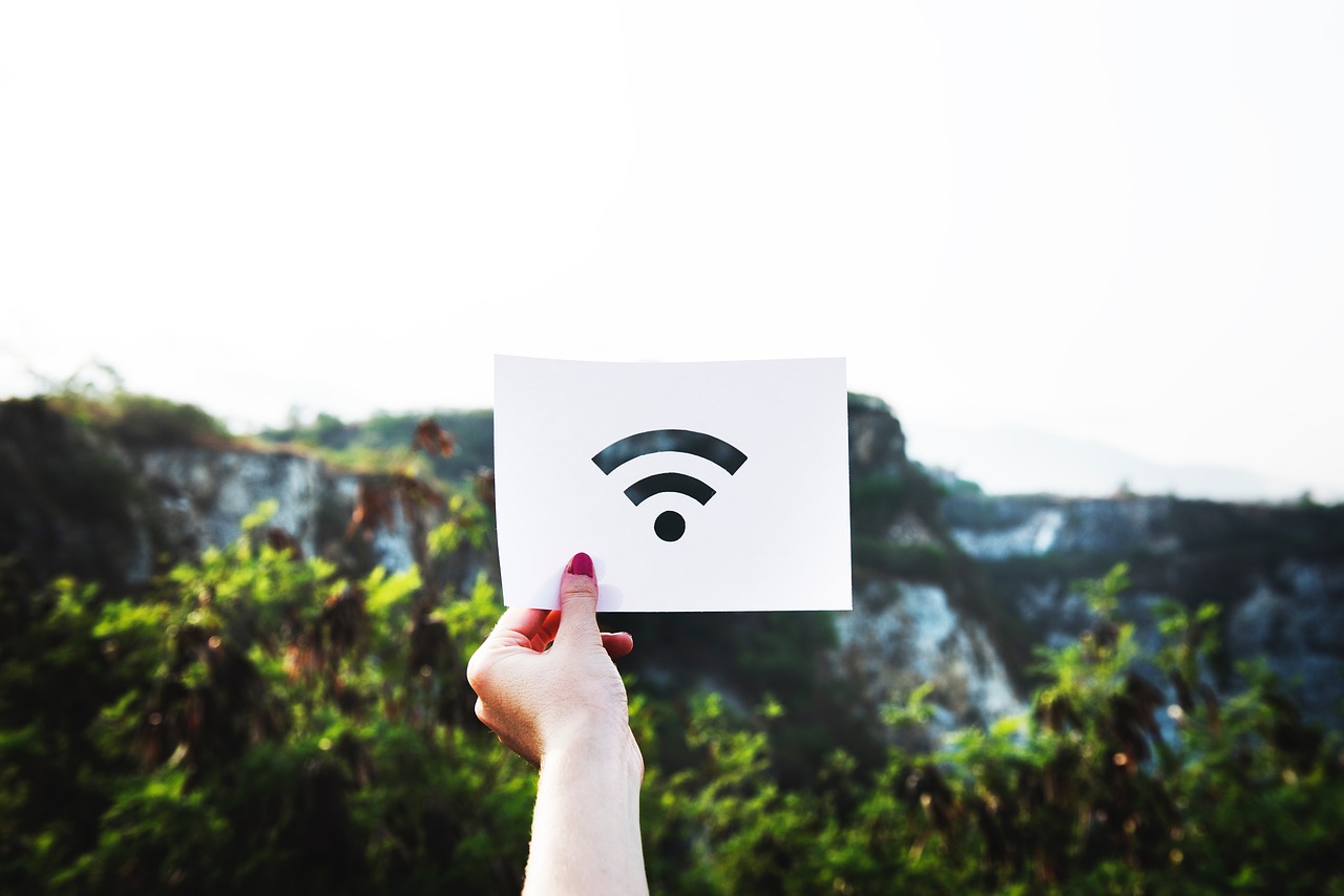 A person holding a paper with a Wi-Fi logo printed to it